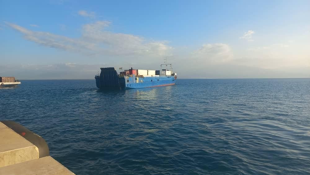 Barge carrying shipping containers along the Haitian coast